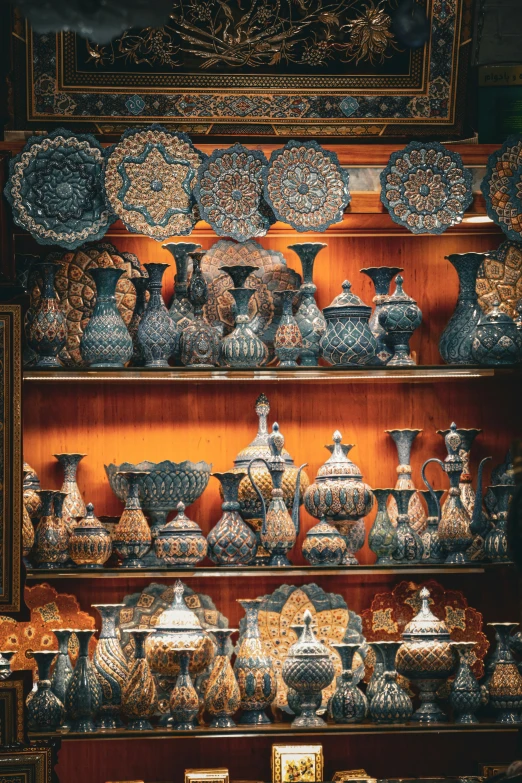 a shelf full of vases sitting next to other items