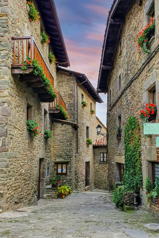 an alleyway in the village with flowers growing on the windows