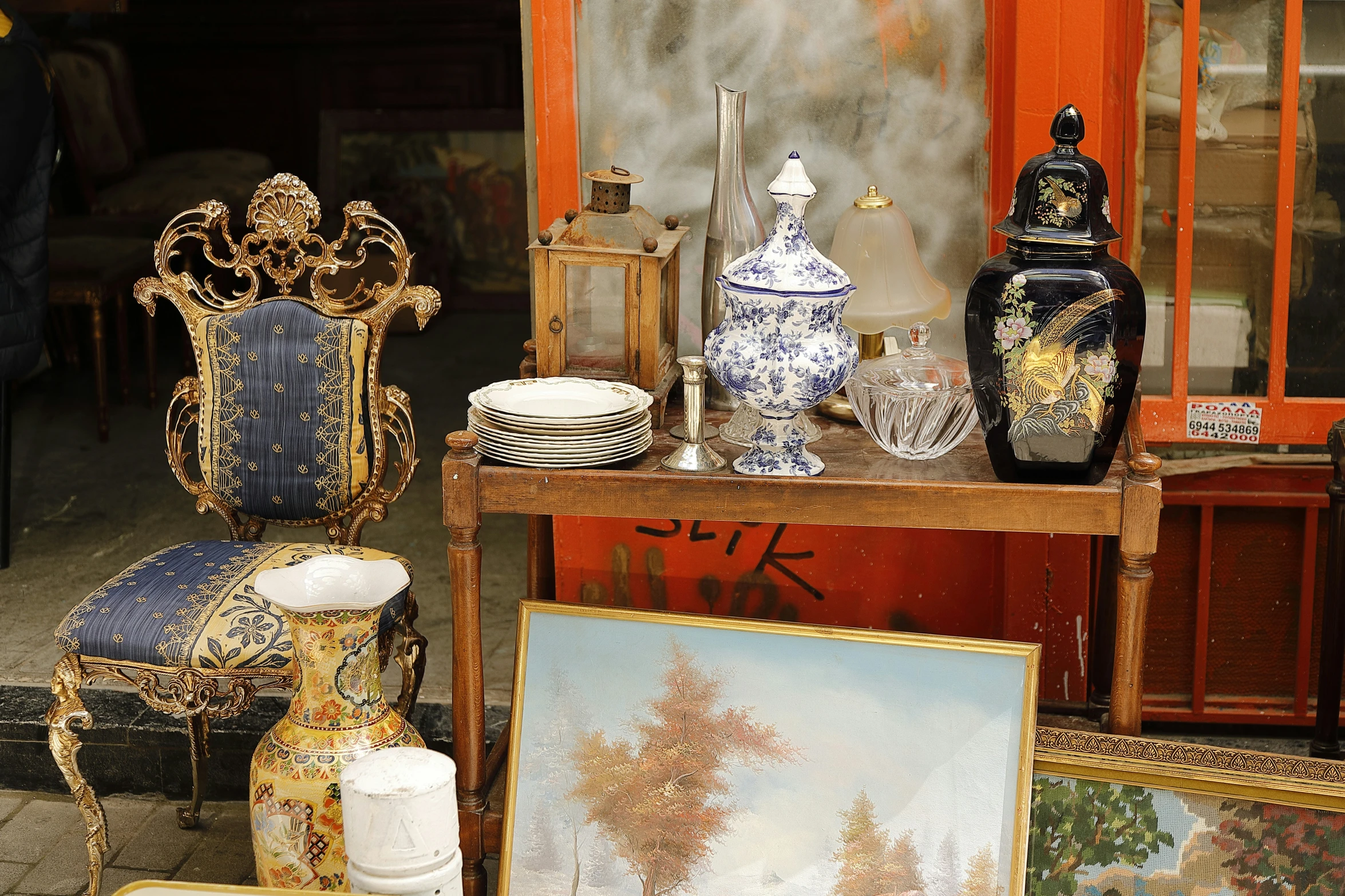 many vases and paintings sit near a wooden table