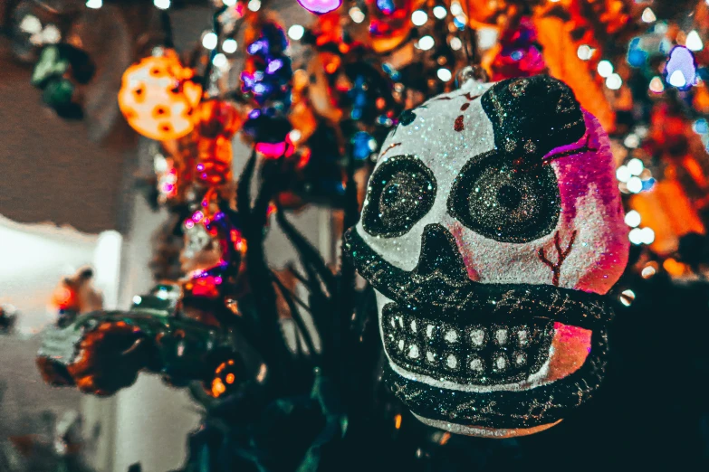 a skeleton mask sitting in front of an assortment of hanging decorations
