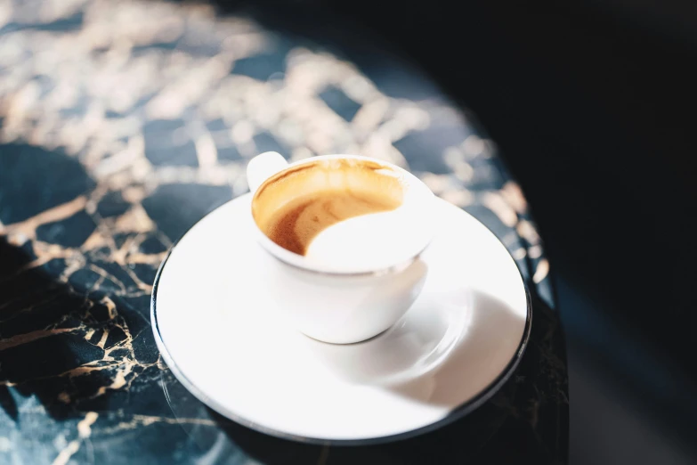 a cup of coffee sitting on top of a black table