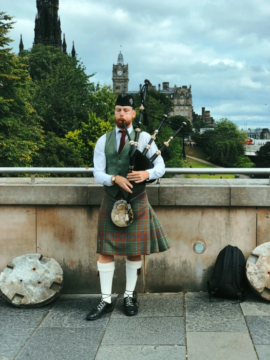a man is standing with a bagpipe in his hand