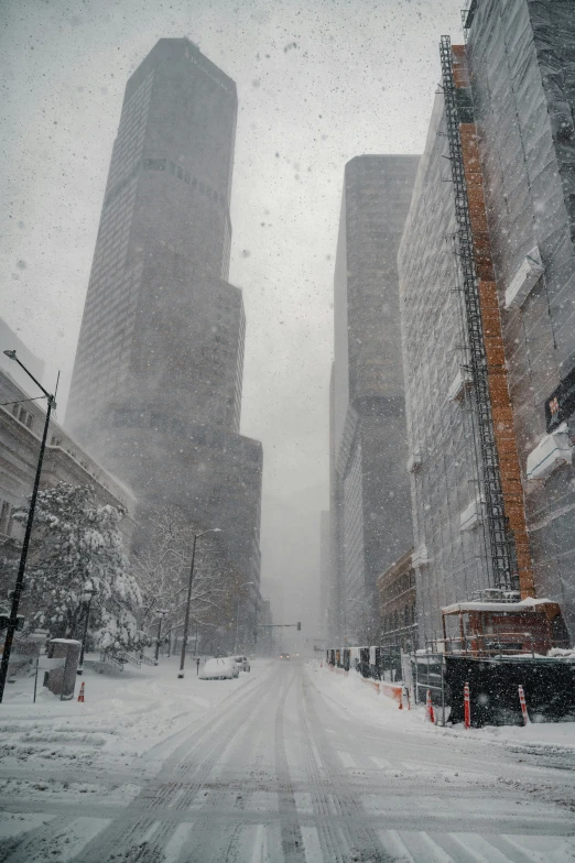 a street covered in snow next to tall buildings