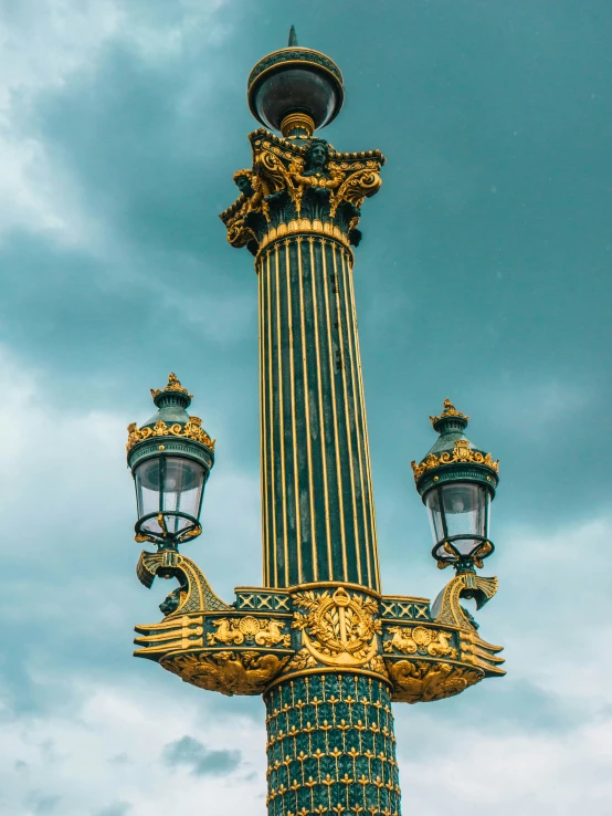 a light fixture in front of a cloudy sky