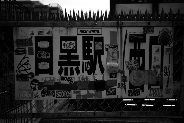 a bunch of signs and a fence covered with graffiti