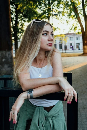 a beautiful young woman sitting on top of a bench