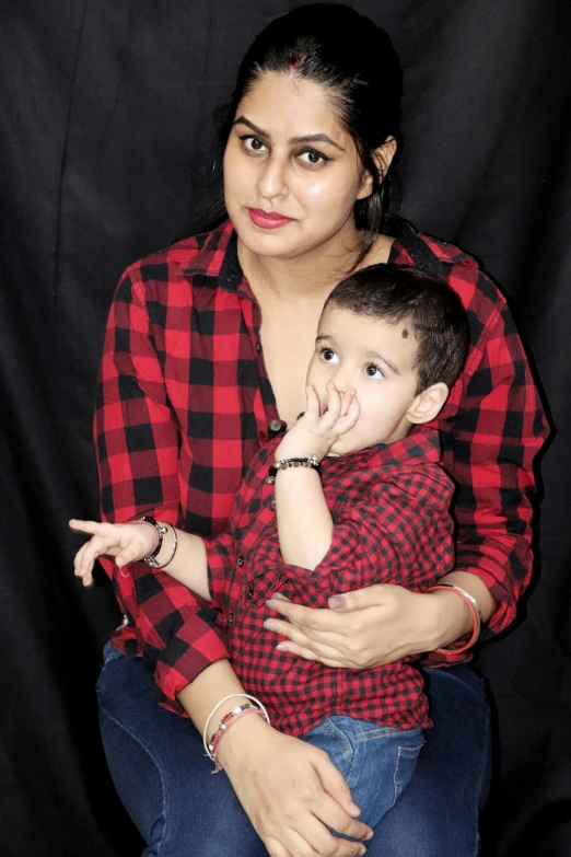 a woman in red shirt sitting next to a child