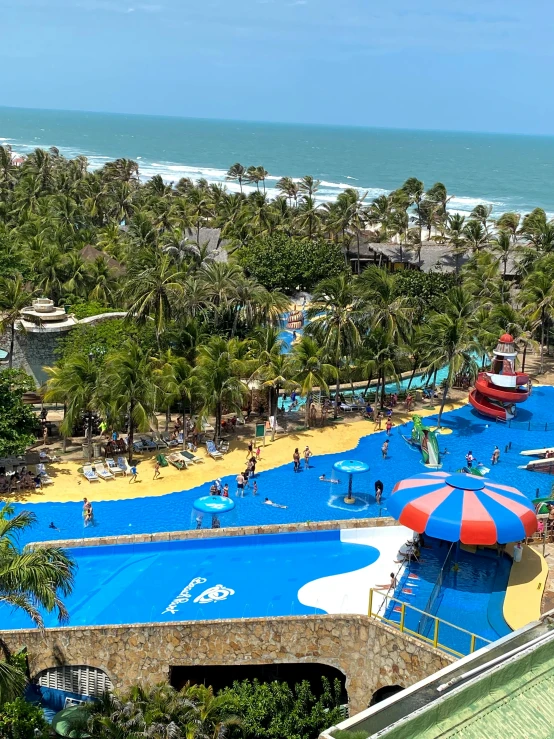 a swimming pool with blue covers in the middle of palm trees