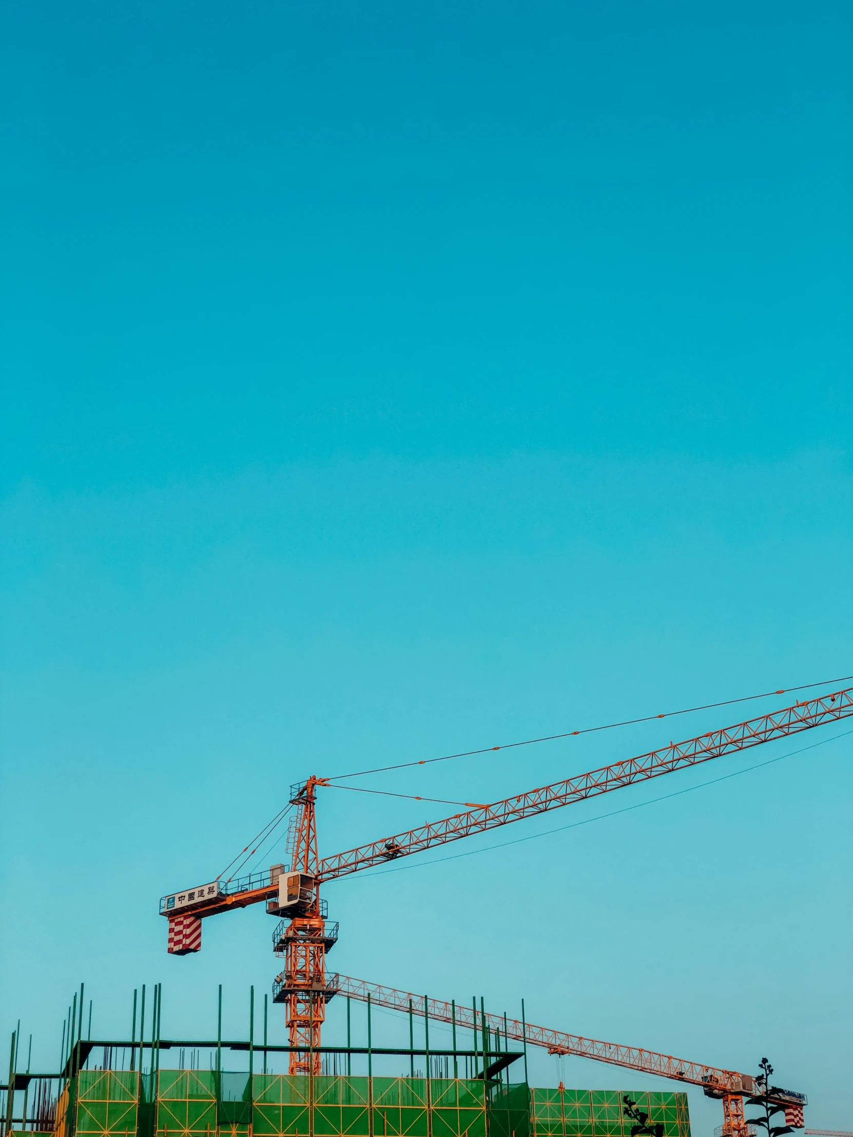 two cranes that are sitting on top of some construction