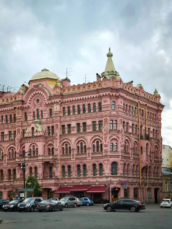 a large pink building that has two domes on it