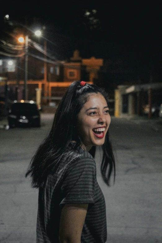 a smiling woman standing by a parking lot