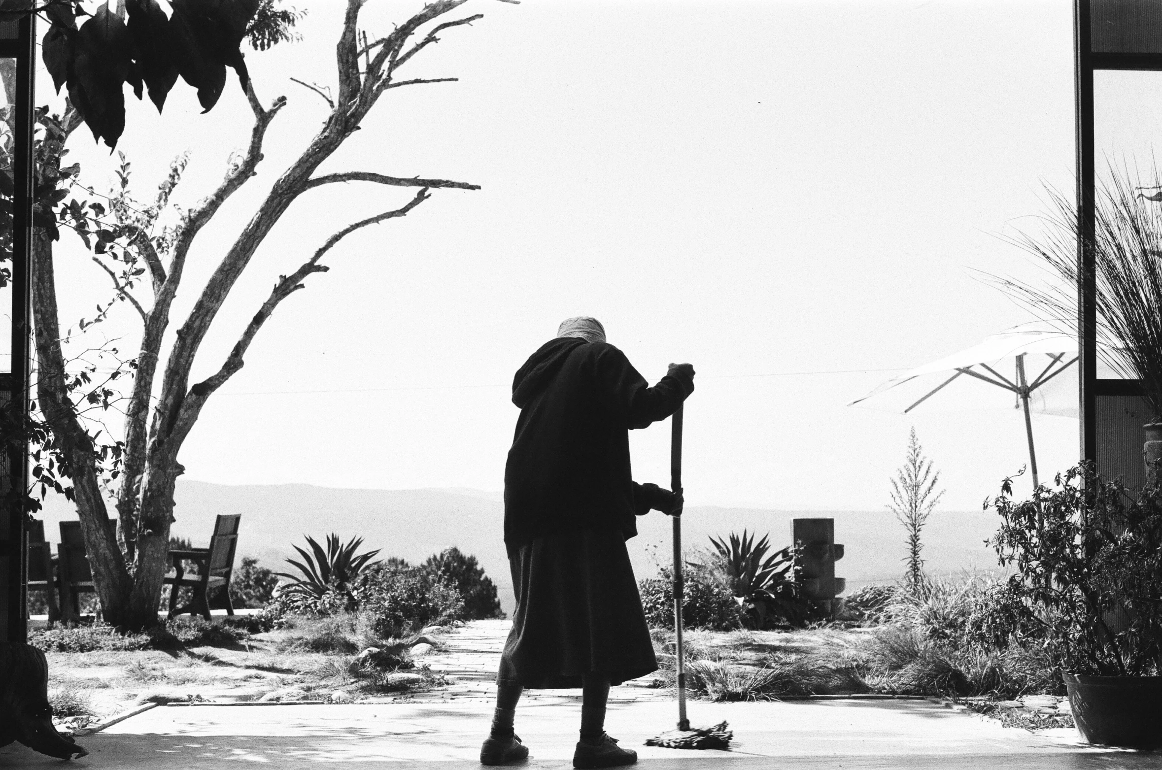 a person on a sidewalk with a walking stick