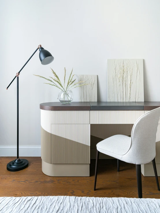 a modern bedroom with two white chairs and a black lamp