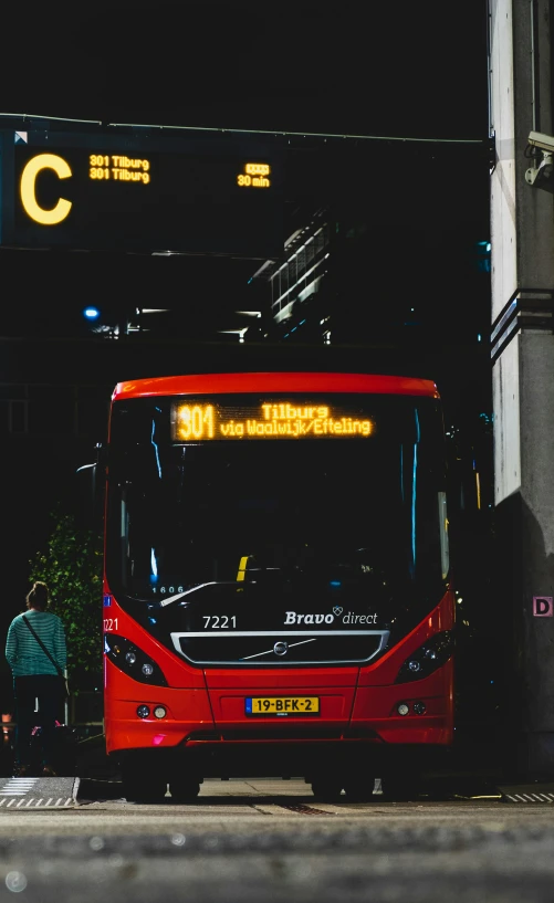 a red bus parked in front of an airport terminal