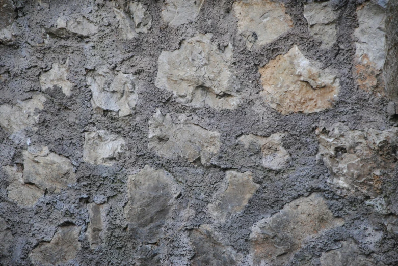a stone wall is covered with rock like objects