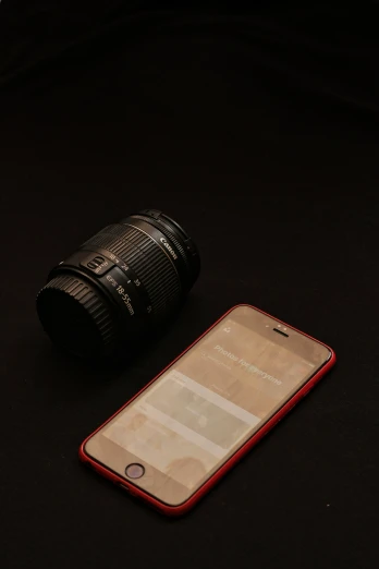 a cell phone sitting next to a camera lens
