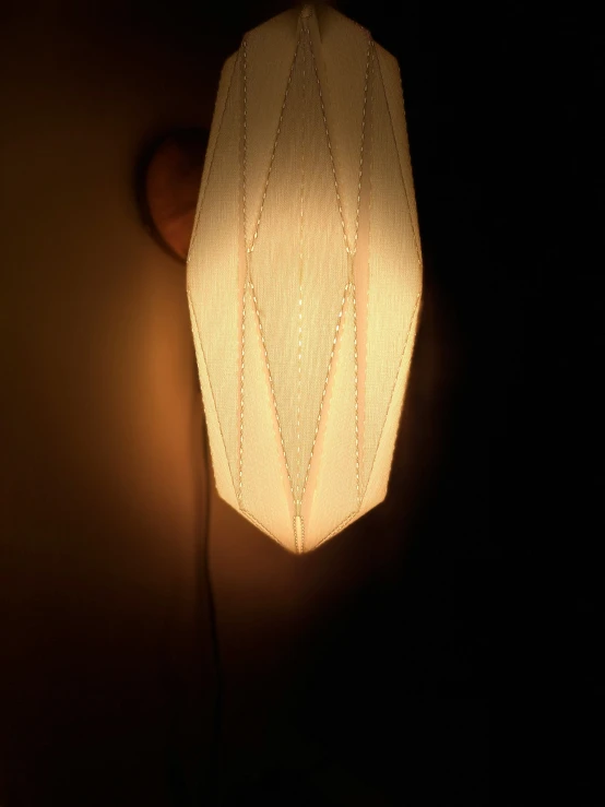 a small light shade on the wall hanging from the ceiling