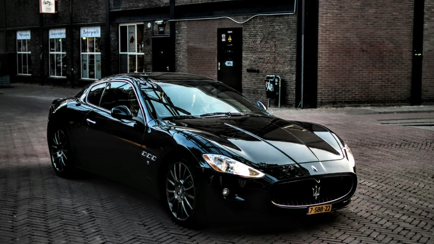 a masera parked on the side of a street in front of a building