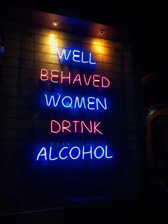 a neon sign saying well behaved women, drink alcohol and care