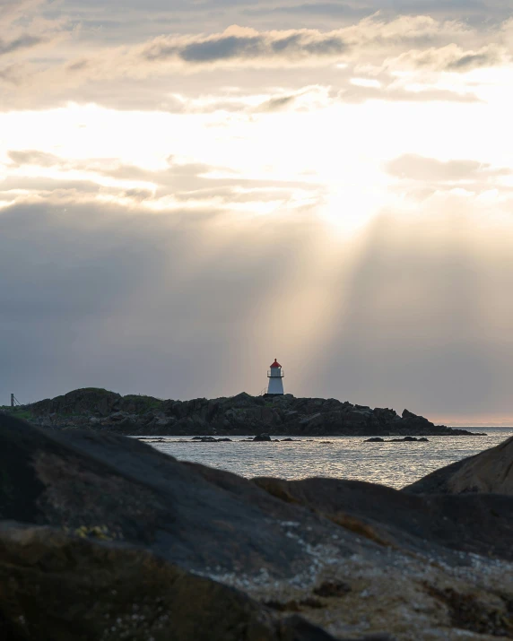 a lighthouse is pictured against a cloudy sky