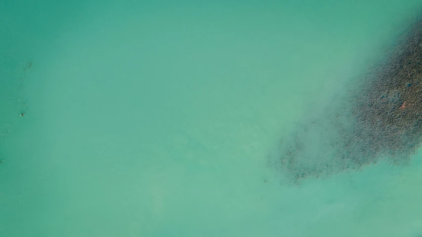 an aerial view of the ocean near the sand