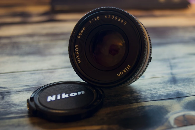 an old camera lens sitting on top of a wooden table