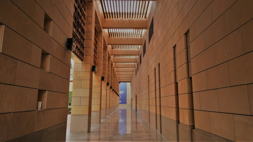 a long hallway has brick walls and tiles lining the floor