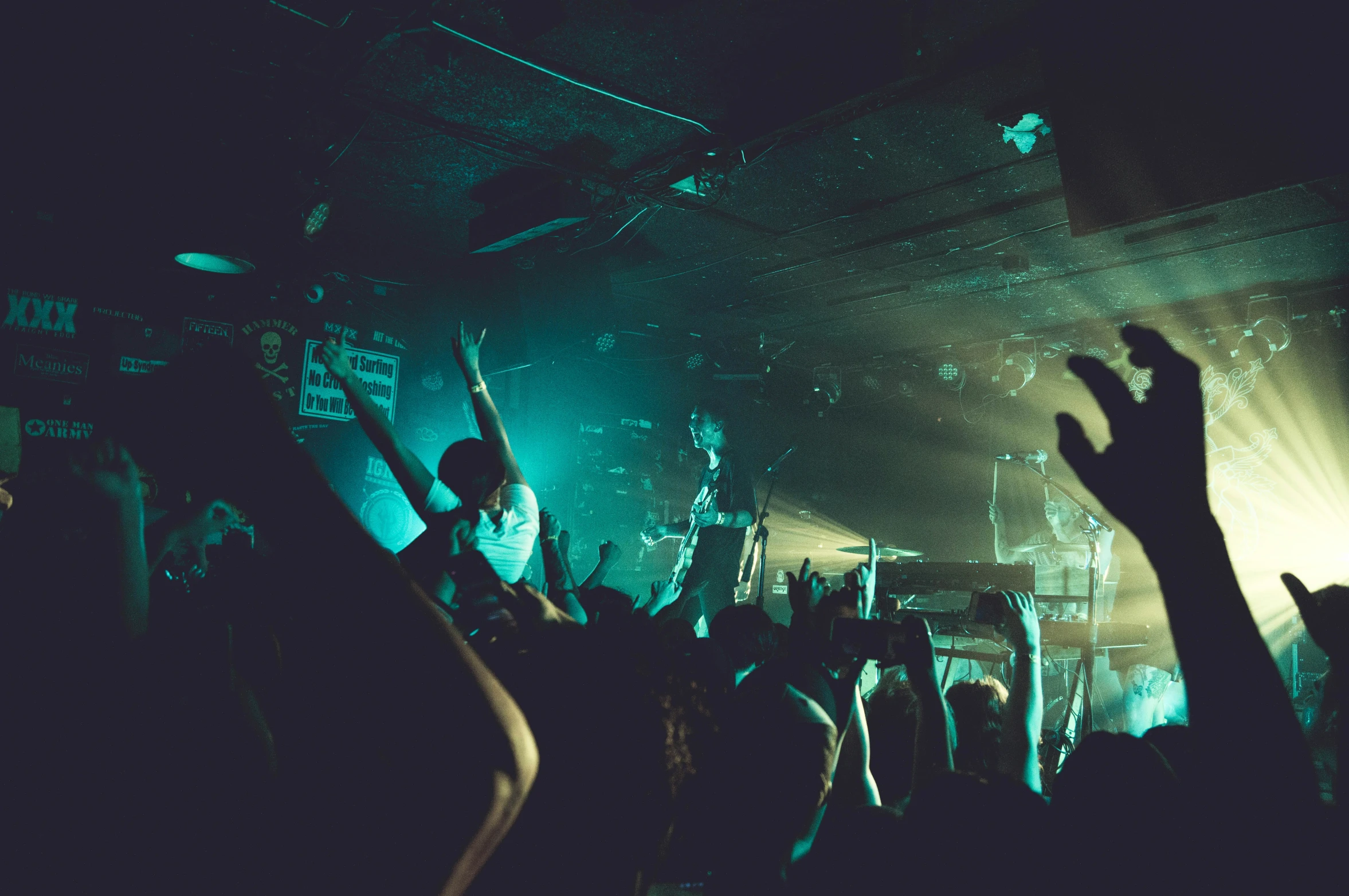 a band of people at a concert, one is reaching up