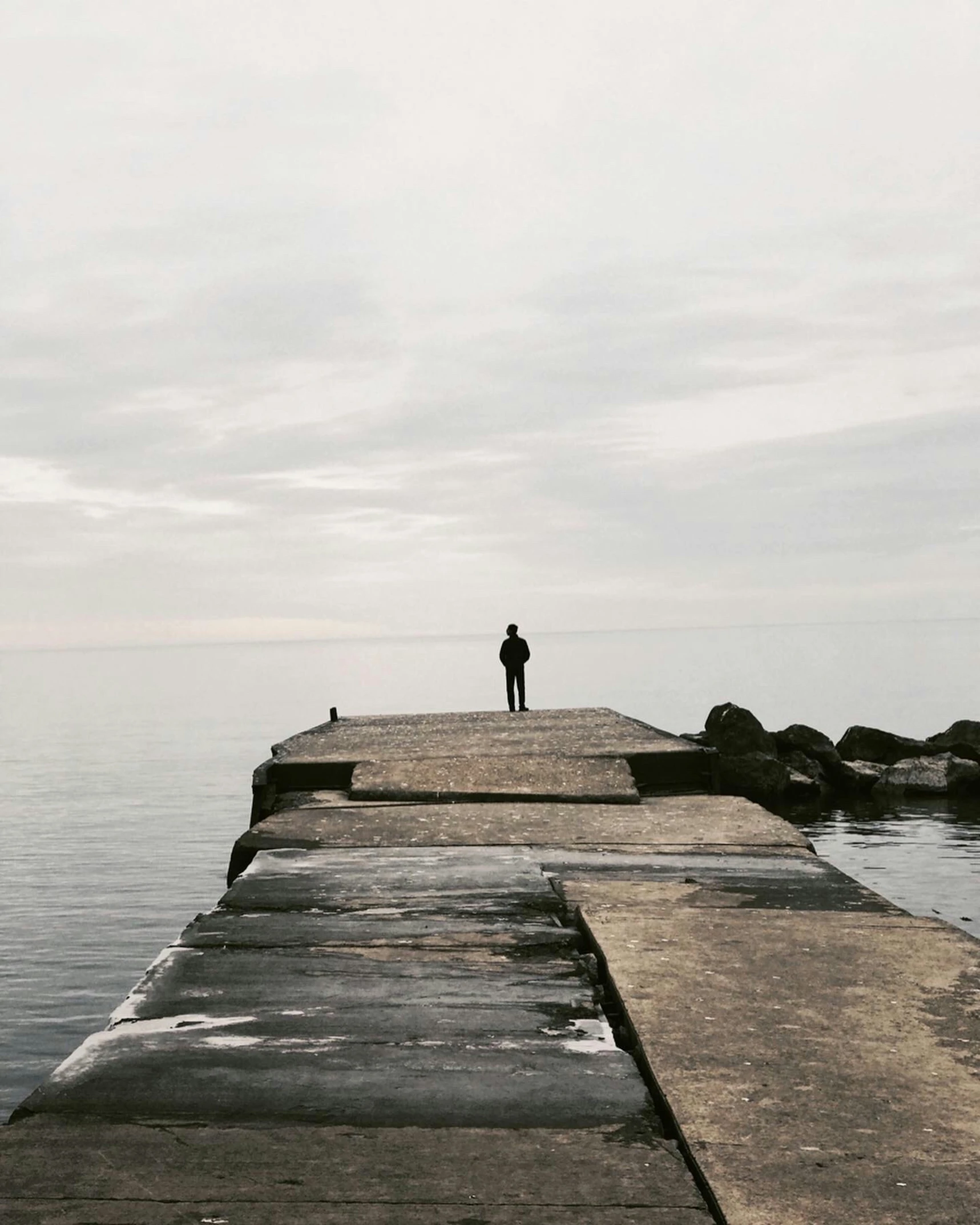 the man stands alone on the old pier