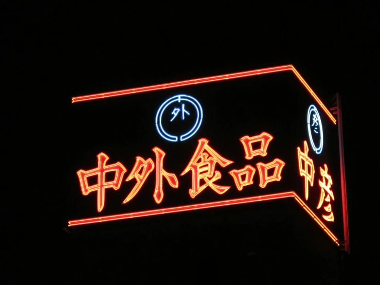 a dark sky has a neon sign and an asian language