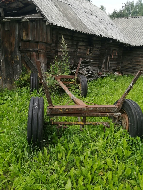 a plow is parked outside of an old run down farm house