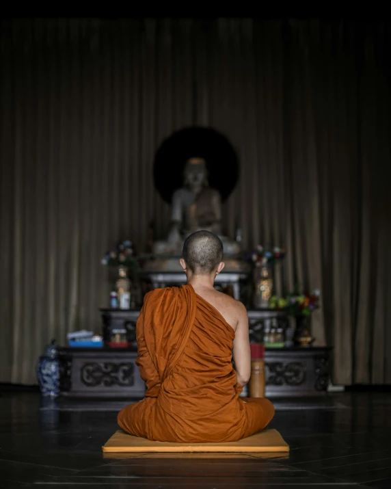 a man in an orange robe is sitting