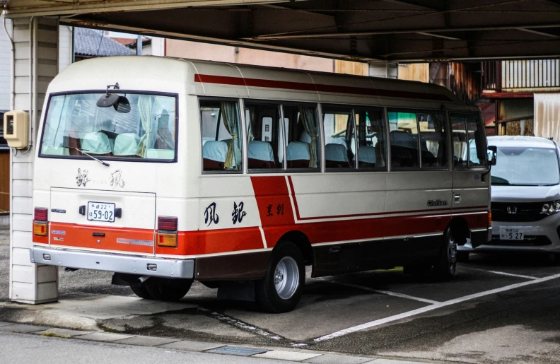 a bus parked under a parking garage next to another car
