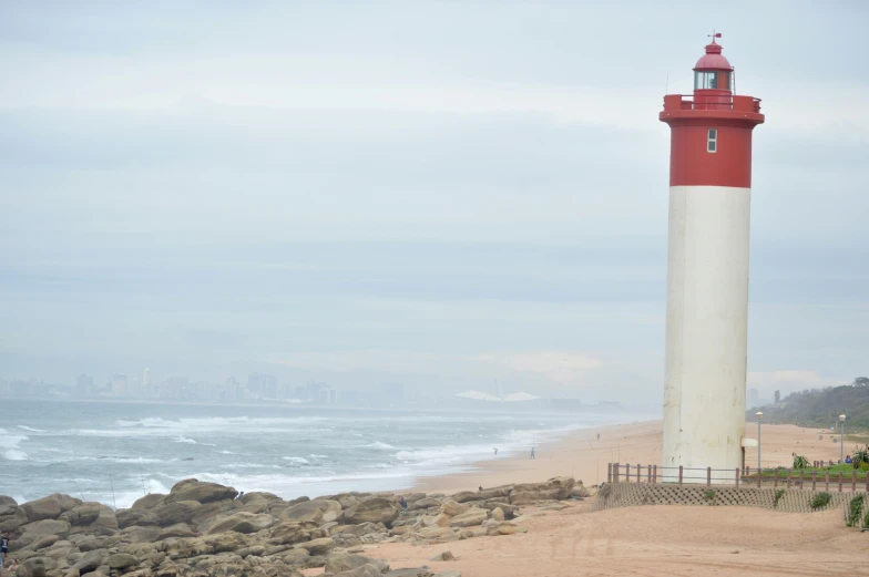 a very tall white lighthouse on the coast