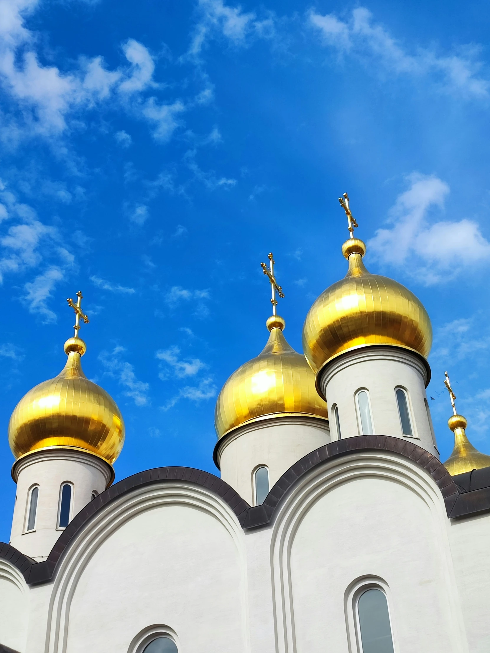 an old church has two golden domes and crosses on it