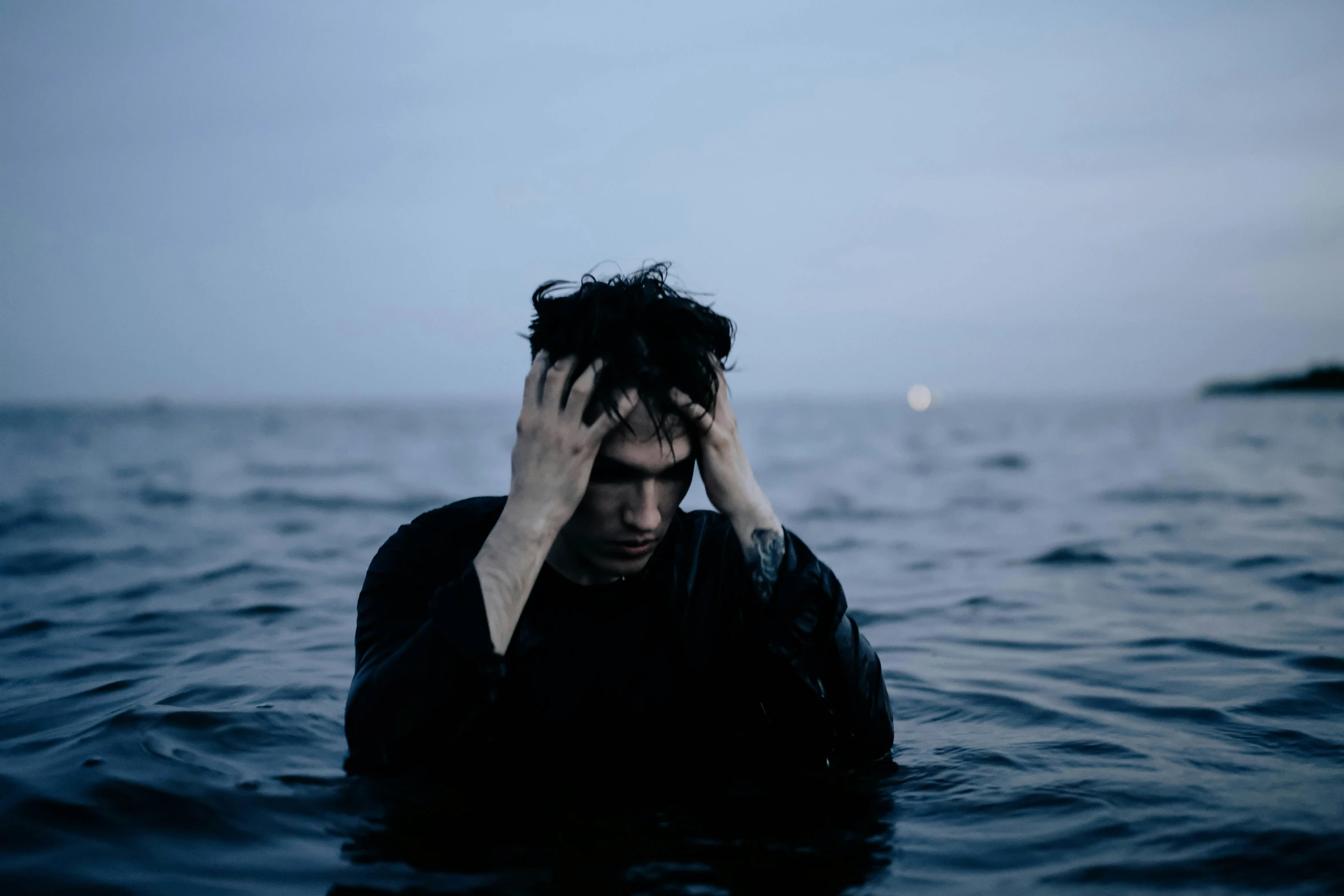 a man standing in the water holding his head