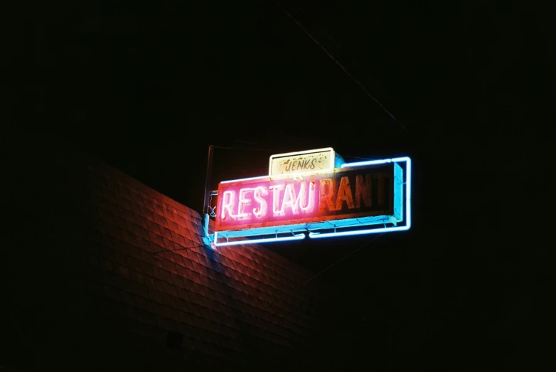 a neon sign hangs off the side of a building