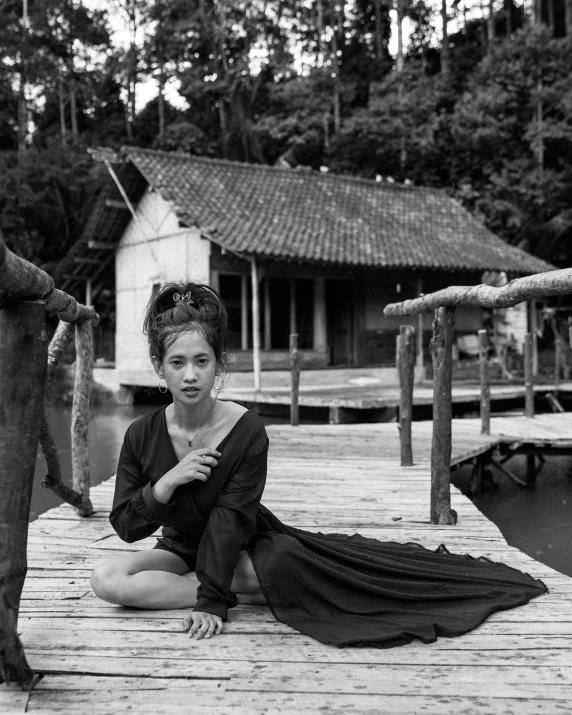 the young woman is posing on the pier