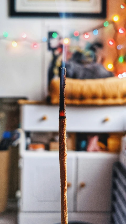 a candle sitting in the middle of a room next to a bed