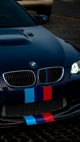 a black bmw car has colorful stripes on the hood