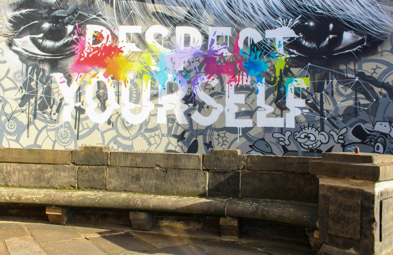 a graffiti painted wall with benches in front of it