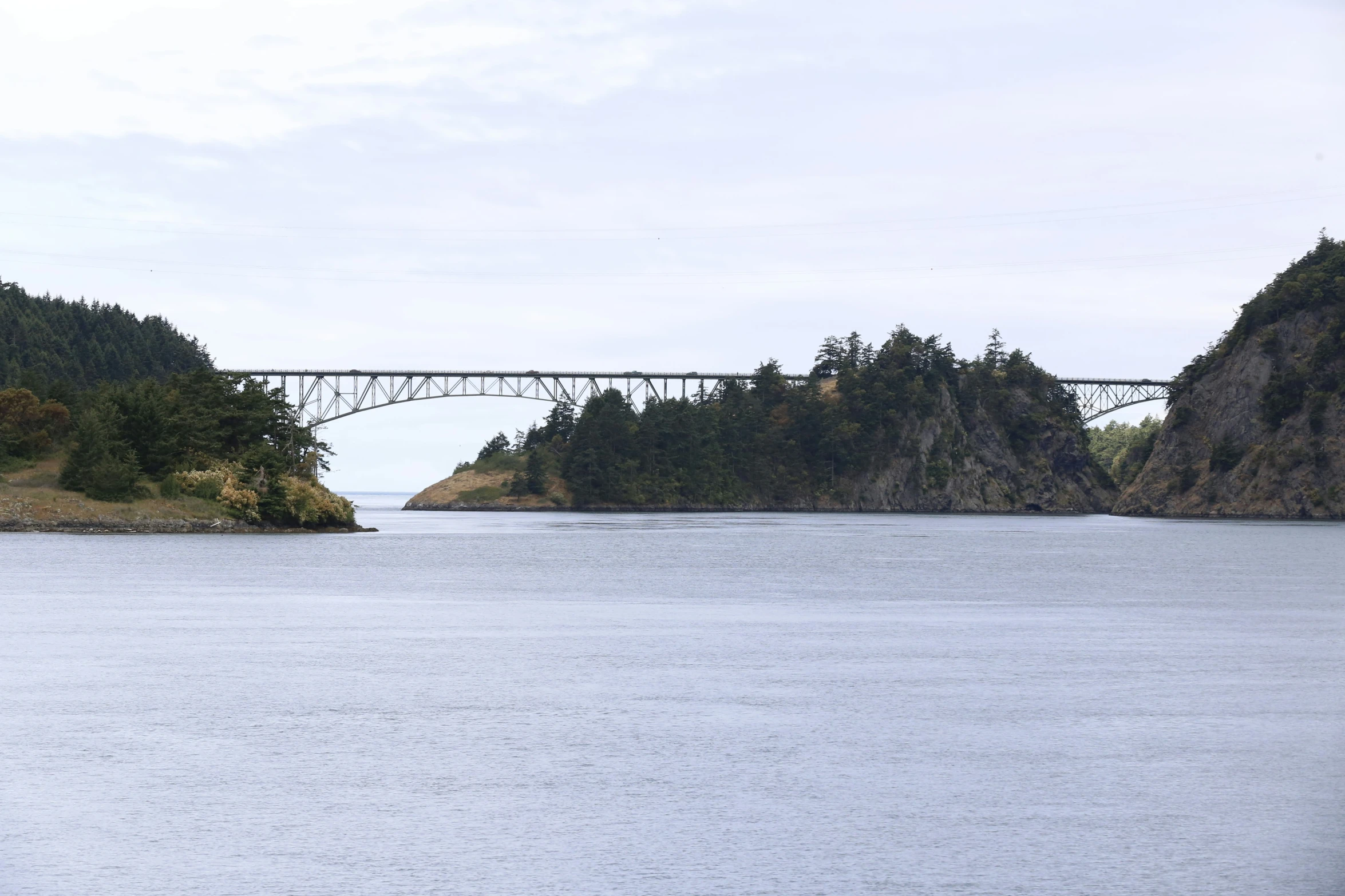 an bridge is above water near mountains