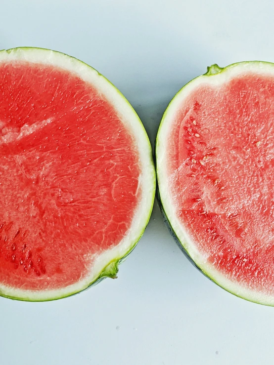 two pieces of watermelon are sitting side by side