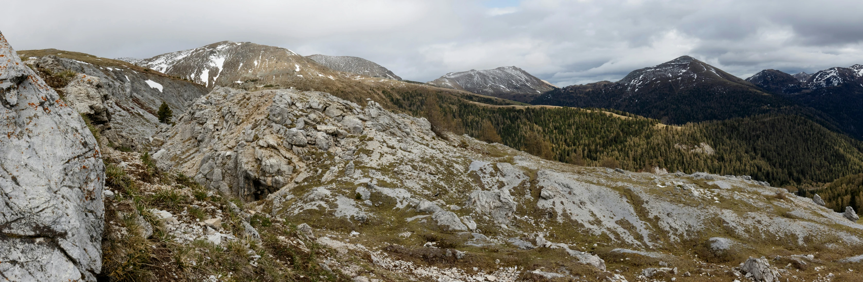 a mountain range on a cloudy day with mountains in the background