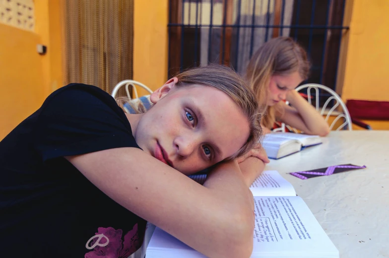 two women sitting at a table with paper