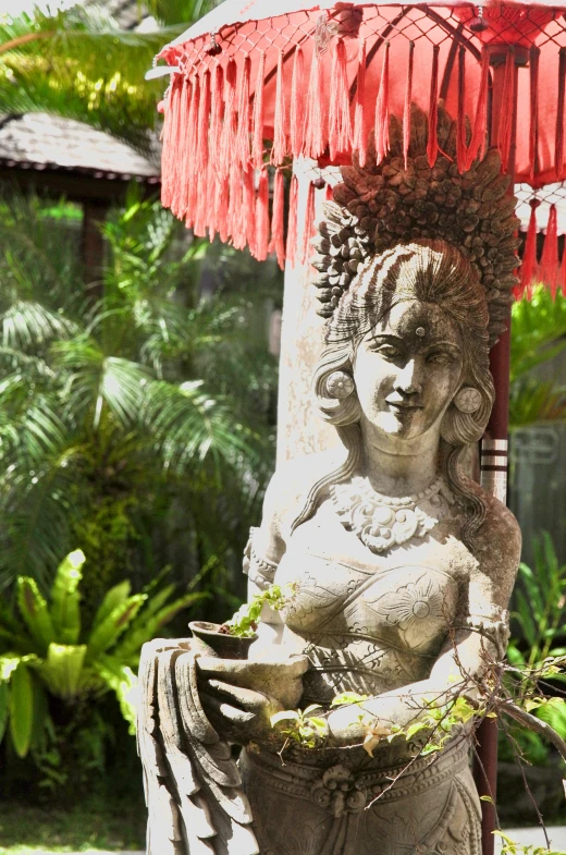 a statue and red umbrella on an outside patio