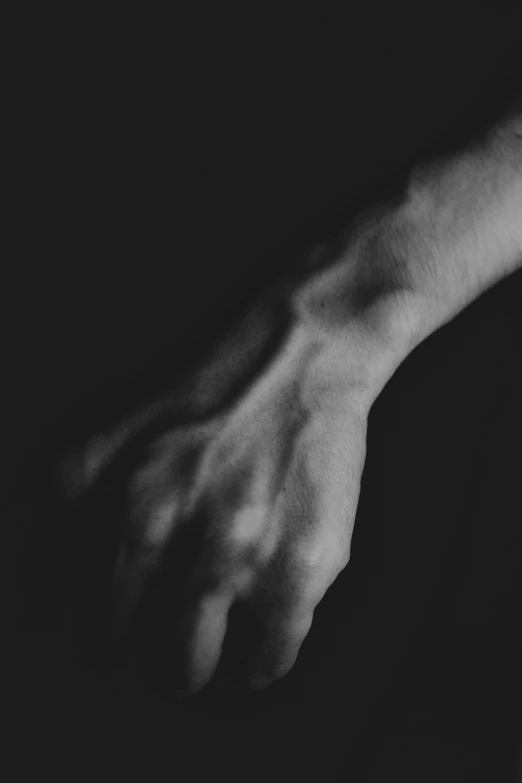 a hand reaching towards the wall with dark background