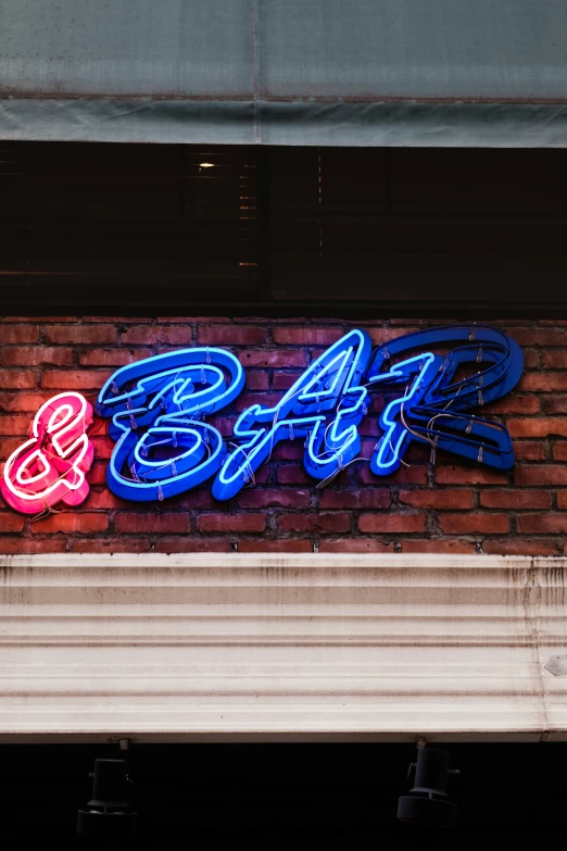 a lit up neon sign on the side of a building