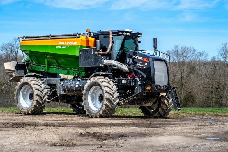 a green, yellow and black truck parked in mud