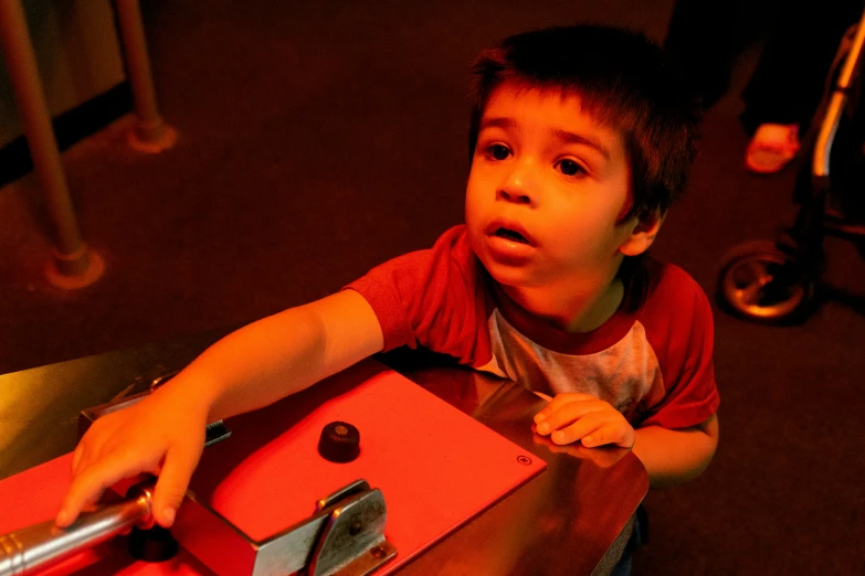 a little boy holds a pink box on a table